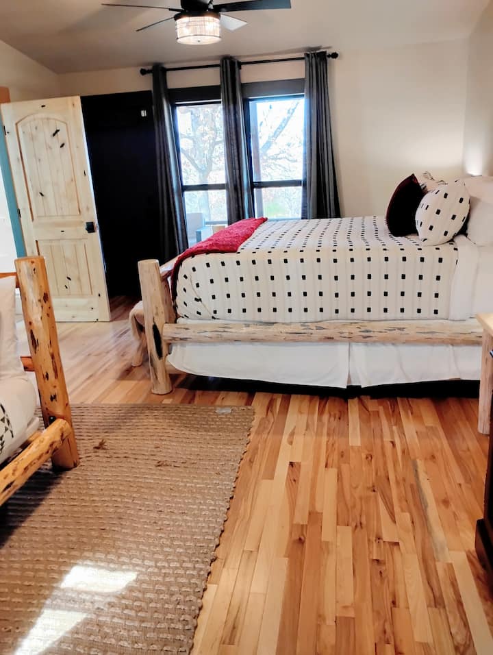 הנה מיטת הקינג סייז בחדר השינה הראשי הגדול במיוחד, שיש בו גם מיטת קומותיים בקצה השני עם מיטת קומותיים עם מיטת יחיד על מיטת קווין סייז הפונה לטלוויזיה בגודל 40 אינץ'.