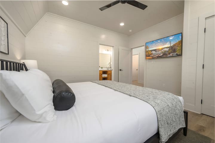 Modern bedroom featuring en suite bathroom and minimalist decor.
