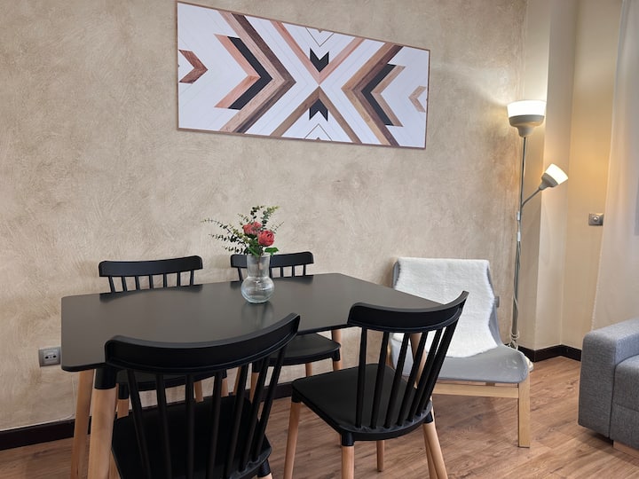 Comedor con mesa negra y sillas de diseño: elegante y luminoso para las comidas.