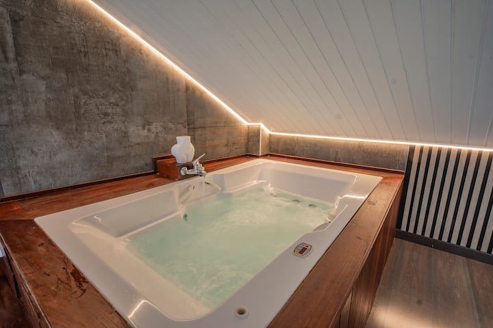 Jacuzzi privado de hidromasaje con luz cálida: el rincón perfecto para relajarse en pareja.