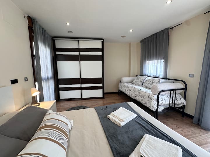 Dormitorio 2 con cama, armario de puertas correderas y sofá: amplio y muy luminoso.