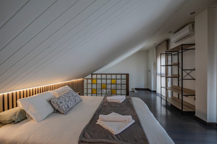 Dormitorio 1 con cama de matrimonio y estantería metálica: amplio y con mucho estilo.