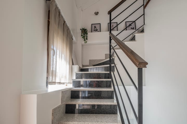 Escalera de diseño que conecta las plantas: distribución moderna y luminosa.