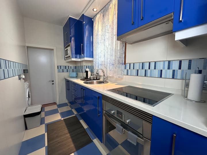 Cocina en azul con vitrocerámica, horno y lavadora: moderna y muy bien equipada.
