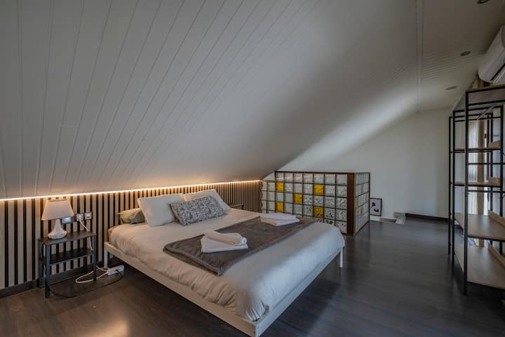 Dormitorio 1 con cama de matrimonio bajo el techo abuhardillado: luminoso y de diseño.