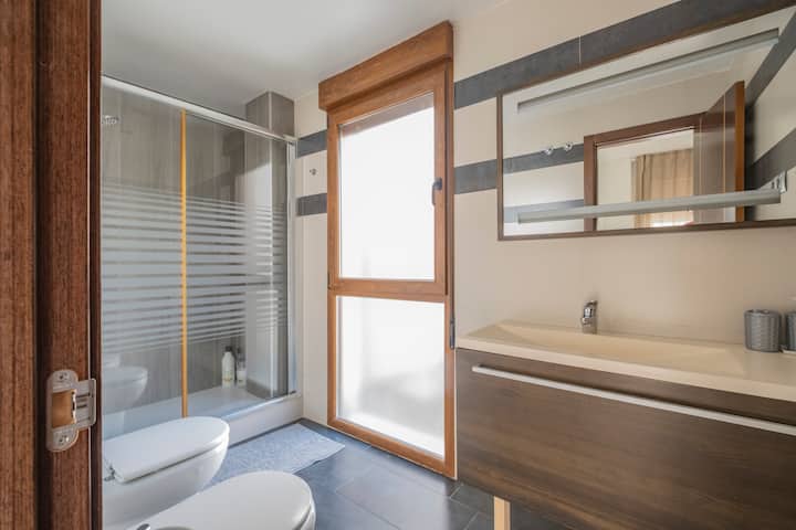 Baño completo con ducha, bidé e inodoro junto a la ventana: amplio y luminoso.