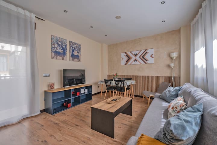 Salón con sofá, mesa de centro y TV: espacio cálido para relajarse en familia.
