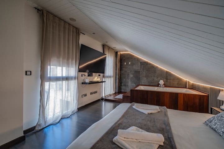 Dormitorio 1 con cama de matrimonio, jacuzzi y ventanal: amplio, luminoso y con encanto.