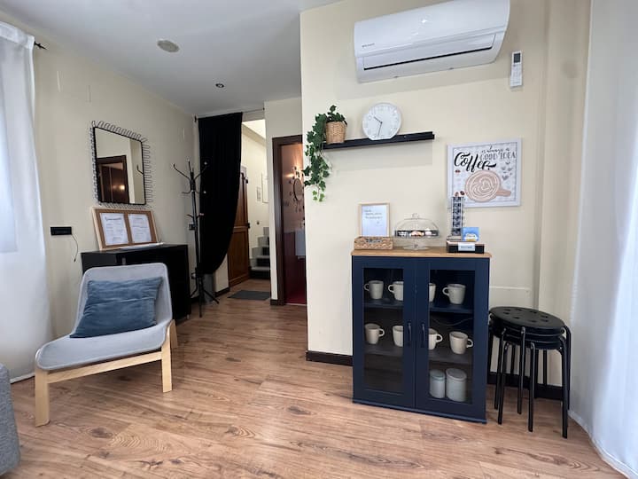 Rincón con butaca, aparador y zona de café: un detalle acogedor para tu estancia.