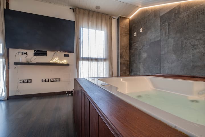 Jacuzzi junto a la ventana y la TV: comodidad y desconexión en el mismo espacio.