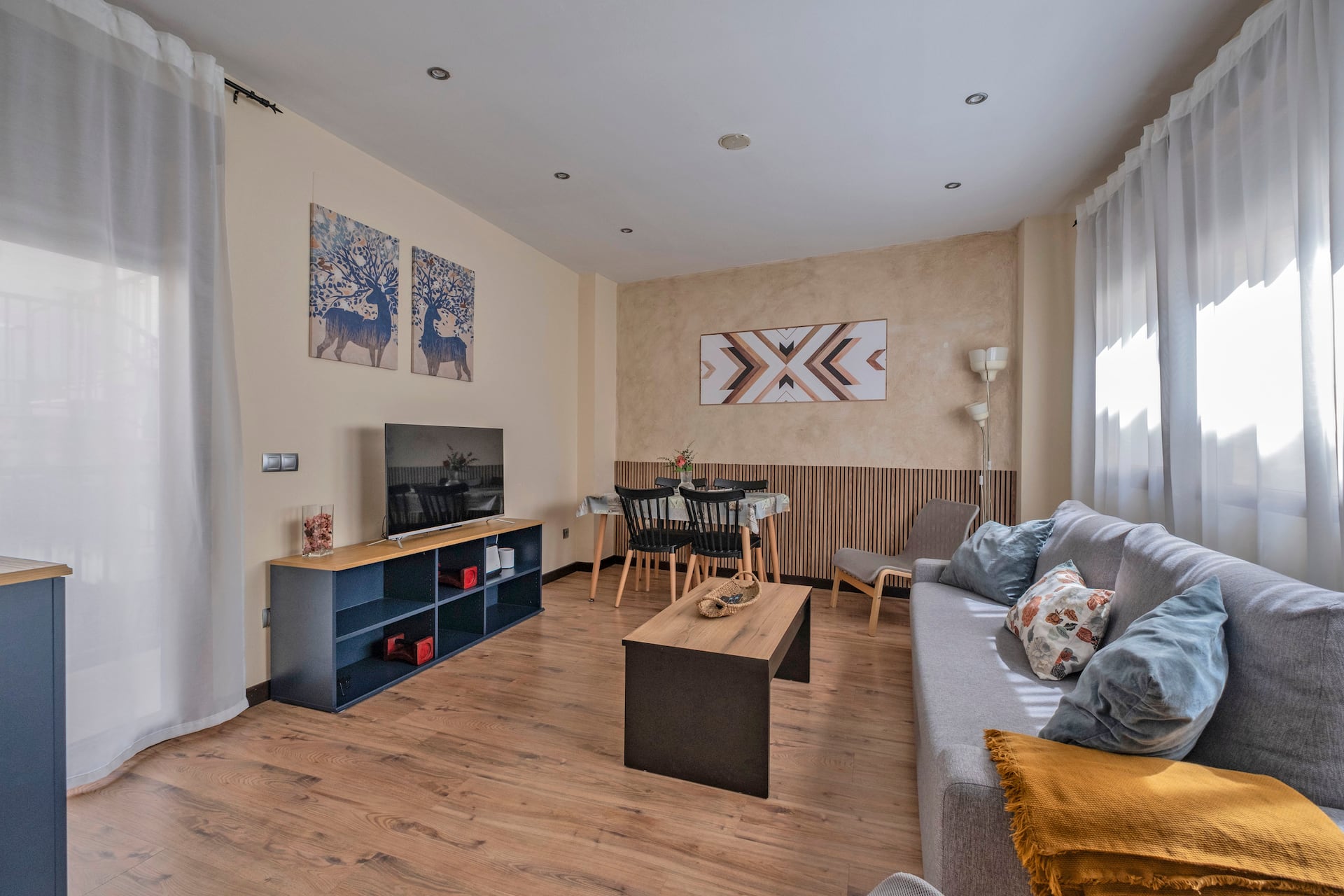 Salón-comedor con sofá, Smart TV y mueble azul: moderno, luminoso y muy acogedor.