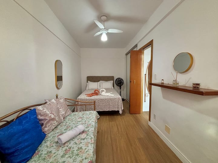 Veľká izba s výhľadom na more, posteľnou bielizňou a kúpeľňou, ochrannou mriežkou okien, stropným ventilátorom, ventilátorom veže, samostatnou posteľou a samostatným matracom.  