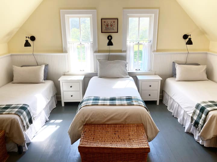 เตียงแฝดยาวพิเศษในห้องสองชั้นของ Carriage House มีเตียงควีนไซส์ในห้องนี้ด้วย