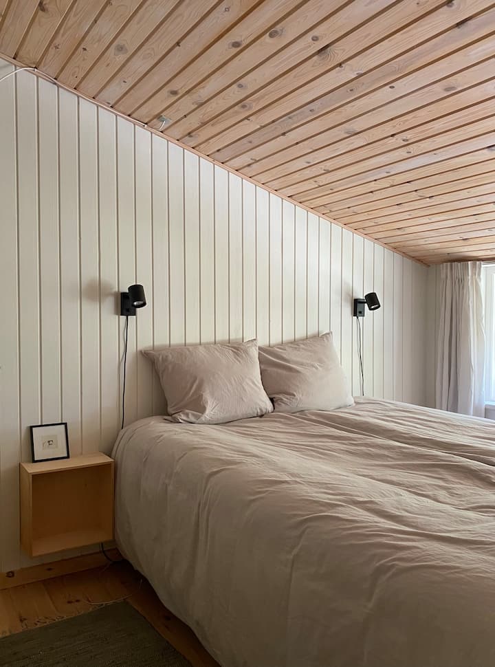 Dormitorio con cama doble y armario. Disfruta de la vista de todo el verde en el bosque mientras pones la cama. 