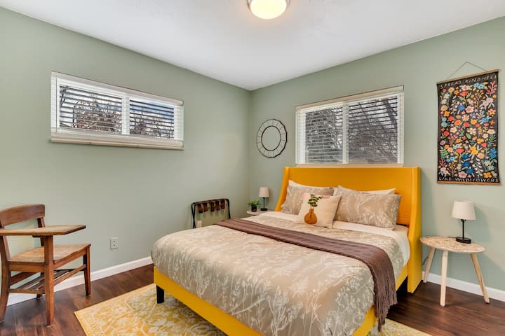 The comfy 2nd bedroom offers a queen size mattress, luggage rack, full-length mirror, hangers,  and small desk 