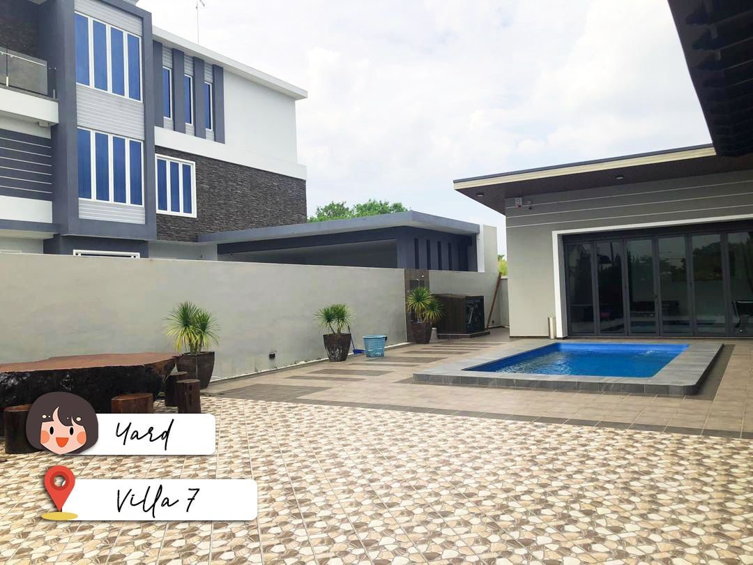 An outdoor area is presented, featuring a modern swimming pool surrounded by a tiled deck. Potted plants are placed strategically along the perimeter, enhancing the space's openness. The architecture showcases a blend of contemporary design with large windows and a spacious layout.