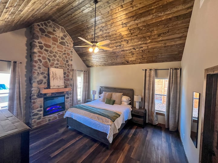 Superbe suite parentale spacieuse avec lit king size, plafond voûté et incroyable cheminée en pierre (électrique). 