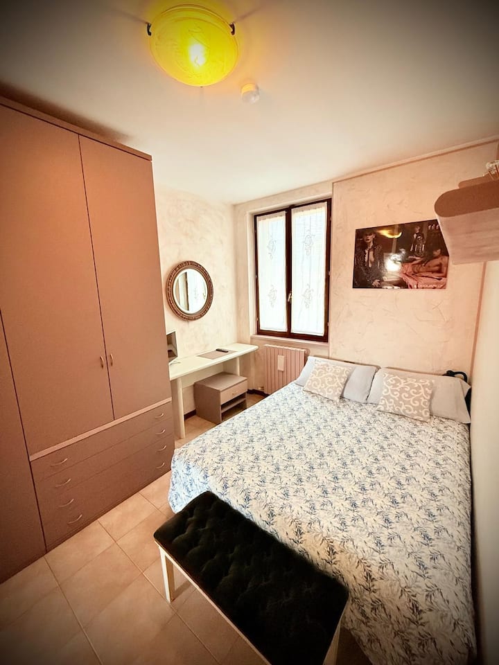 Segundo dormitorio con una cama doble que descansa contra la pared, no hay aire acondicionado, pero un ventilador de columna y TV