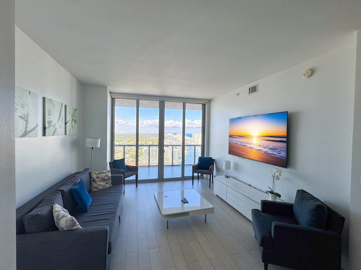 Sala de estar luminosa con acceso al balcón y vistas a la ciudad.