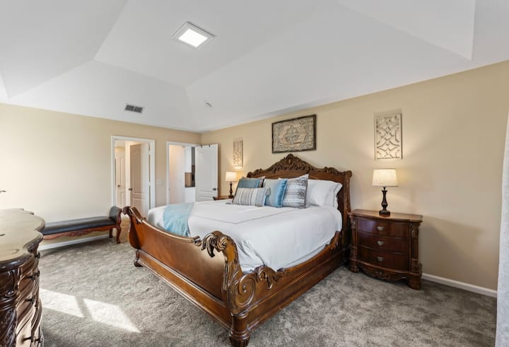 El dormitorio principal cuenta con un cama tamaño king, un baño completo y una bañera de jardín. 