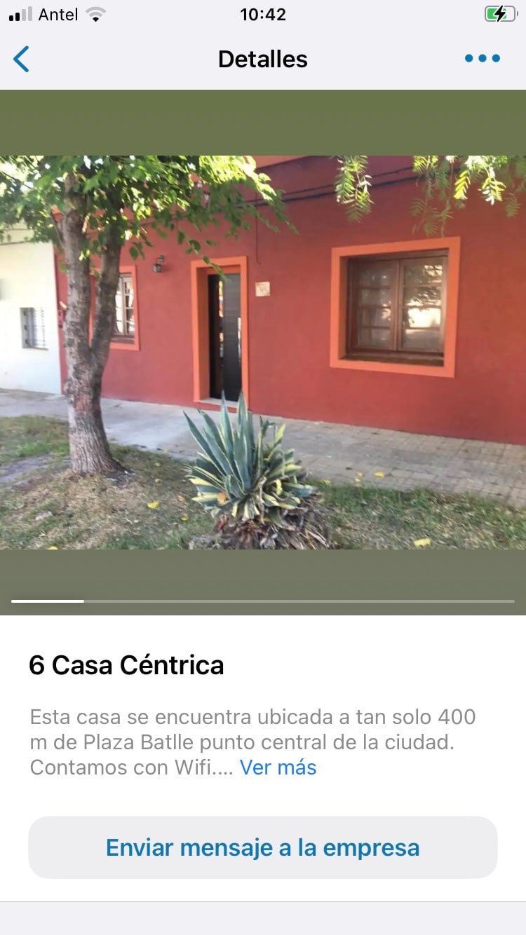 A charming exterior of a red house is displayed, featuring a welcoming entrance. A low-maintenance garden with green plants is visible in front. Nearby, a pathway provides access to the entrance, enhancing the accessibility of the space.