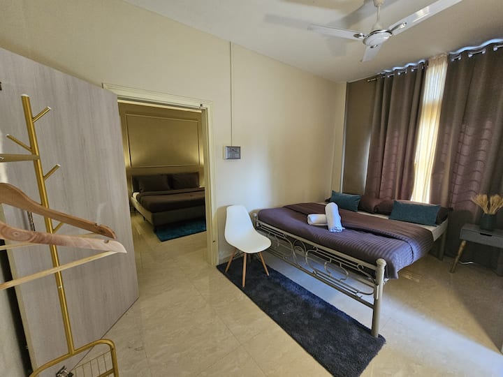 Our 2nd Bedroom is a cozy haven featuring a queen-size bed adorned with luxurious presidential pillows. A clothing rack keeps your wardrobe organized, while the convenience of an attached washroom and kitchen adds a touch of practicality. 