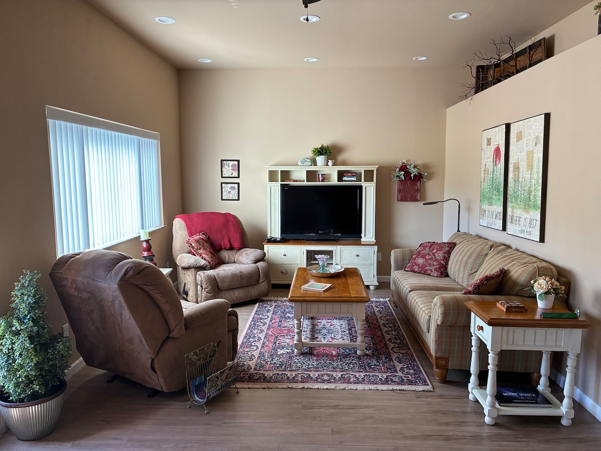 Svetlá a vzdušná obývacia izba so 44-palcovým televízorom a mäkkým pohodlným posedením. Usteľte sa v prikrývke a čítajte, sledujte filmy alebo hrajte hry. Originálne umenie od Julianne.