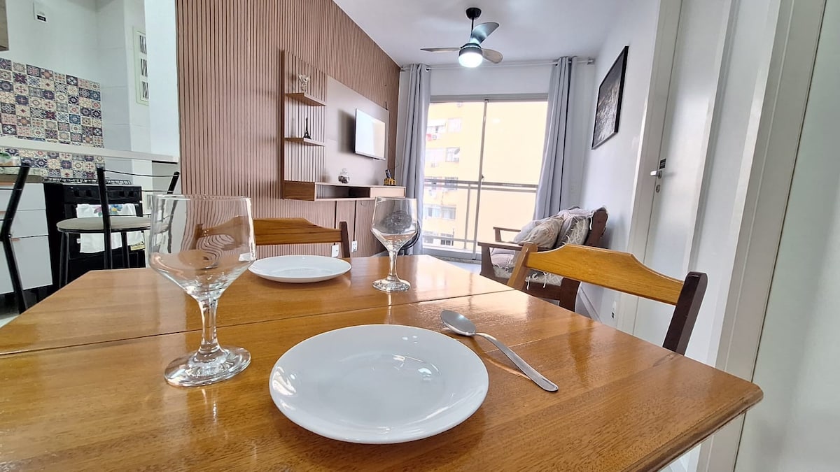 房间宽敞，配有沙发床、智能电视、风扇和餐桌，底部有通往阳台的门