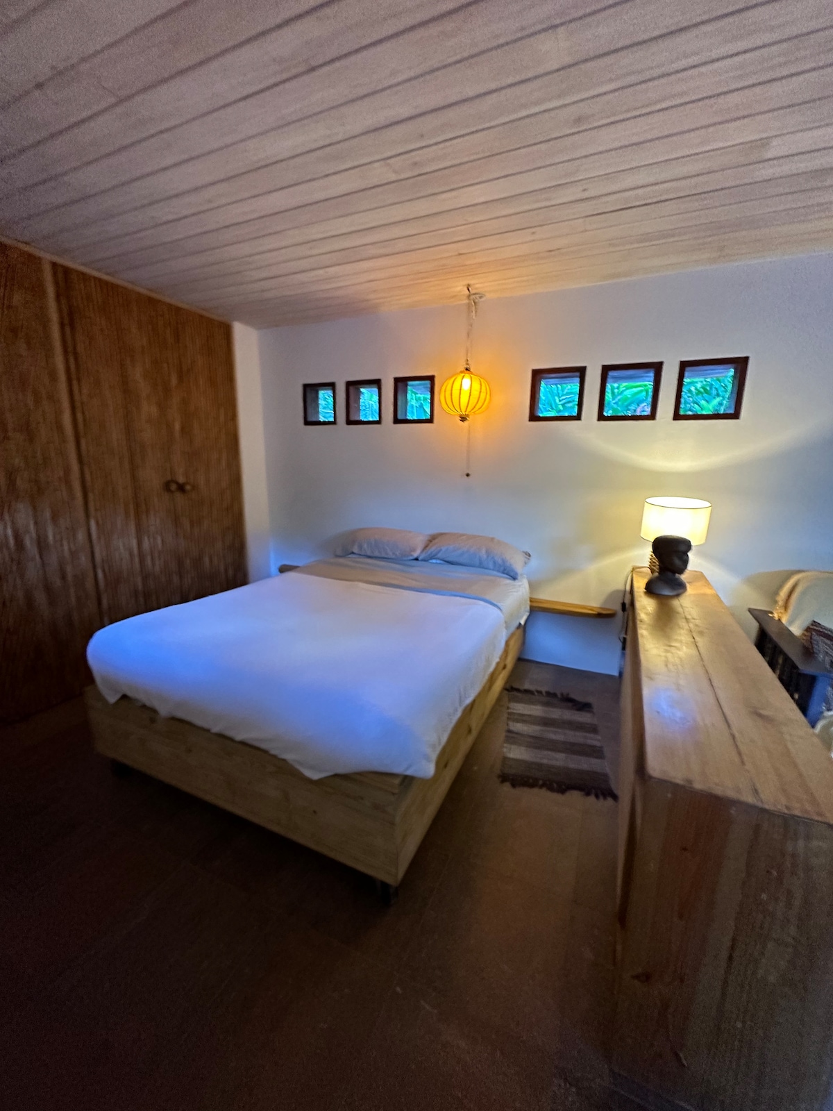 Cómoda cama tamaño queen americana con marco de madera y colchón con muelles. Ropa de cama de buena calidad y cuatro almohadas decentes. Luz junto a la cama y útiles estantes junto a la cama. 