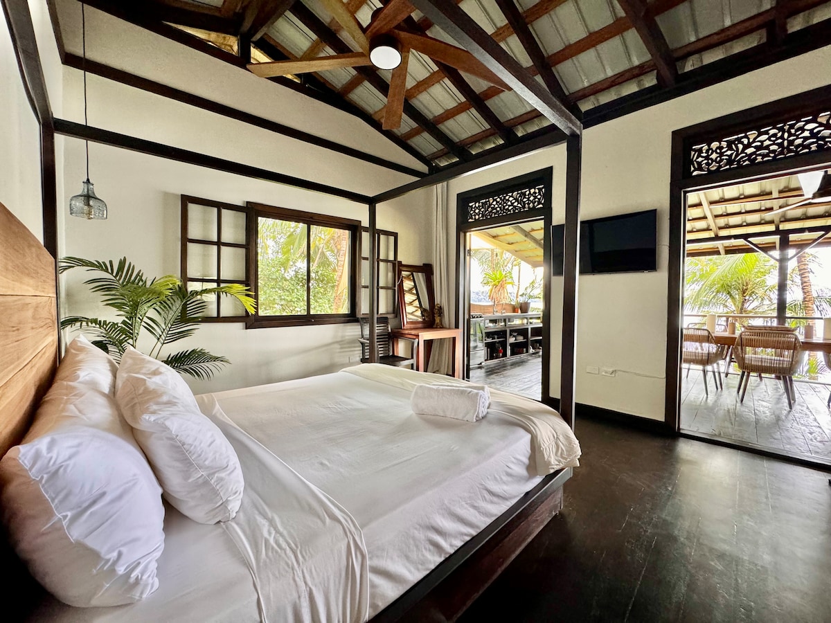 Основна спалня с изглед към океана, смарт телевизор, бюро, вентилатор на тавана. 