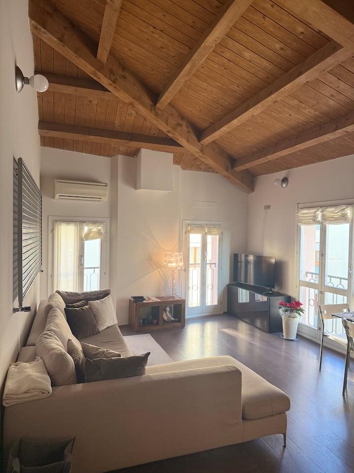 elegantná obývacia izba a pohodlné vysoké stropy s odhalenými trámami, sivými dubovými parketami, tabakovými stenami, pohodlnými ohrievačmi, pohodlnou pohovkou vo farbe L, 43-palcovou inteligentnou televíziou