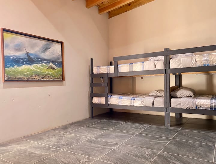 Diseñada para familias o grupos, esta recámara cuenta con una cama matrimonial y tres literas, ofreciendo un espacio acogedor y funcional. Con baño privado dentro de la habitación