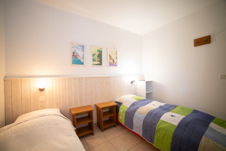 Une chambre spacieuse et confortable, équipée de deux lits simples, idéale pour accueillir familles ou groupes. Un espace agréable qui permet à chacun de profiter d’un séjour reposant.