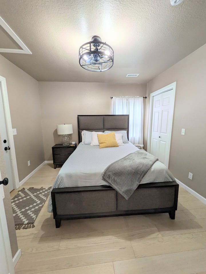 El dormitorio principal incluye una cama tamaño queen y una puerta que conduce al patio trasero.