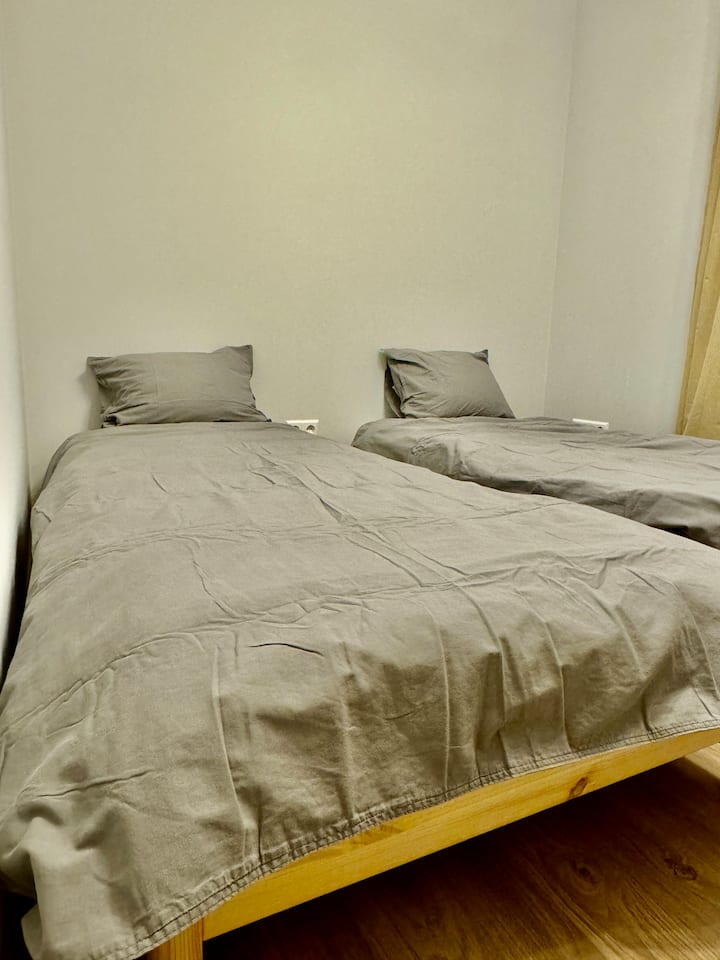 Versatile bedroom with two single beds convertible to a small double or stacked for space-saving. Enjoy ample storage options with a clothing rack, hangers, and access to wardrobes in adjacent rooms/hall