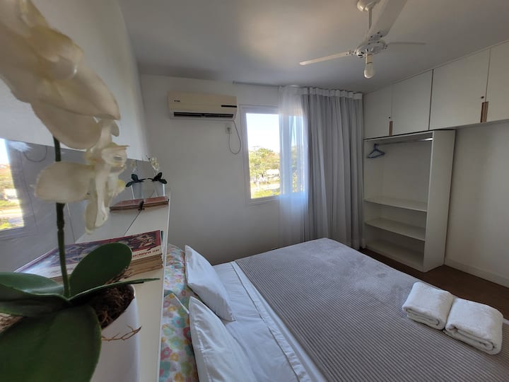 غرفة نوم مع سرير بحجم كينج أو سريرين مفردين، ومروحة منفصلة وسقف. 