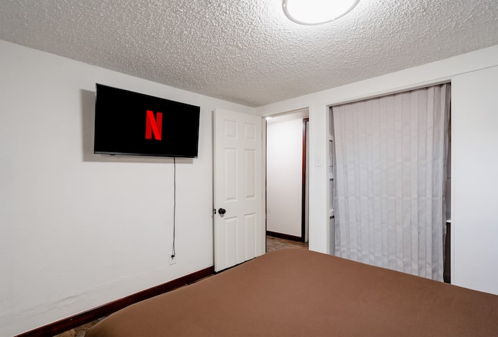 这间卧室设有一张可供两人入住的全尺寸床、一台可观看流媒体电影的智能电视，以及一个可以整理好行李的衣柜。