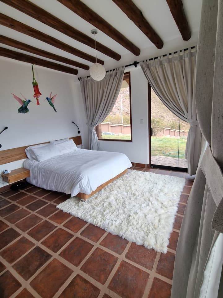 ห้องนอนหลักพร้อมเตียงคิงไซส์ตู้เสื้อผ้าและอ่างอาบน้ำในห้องน้ำ