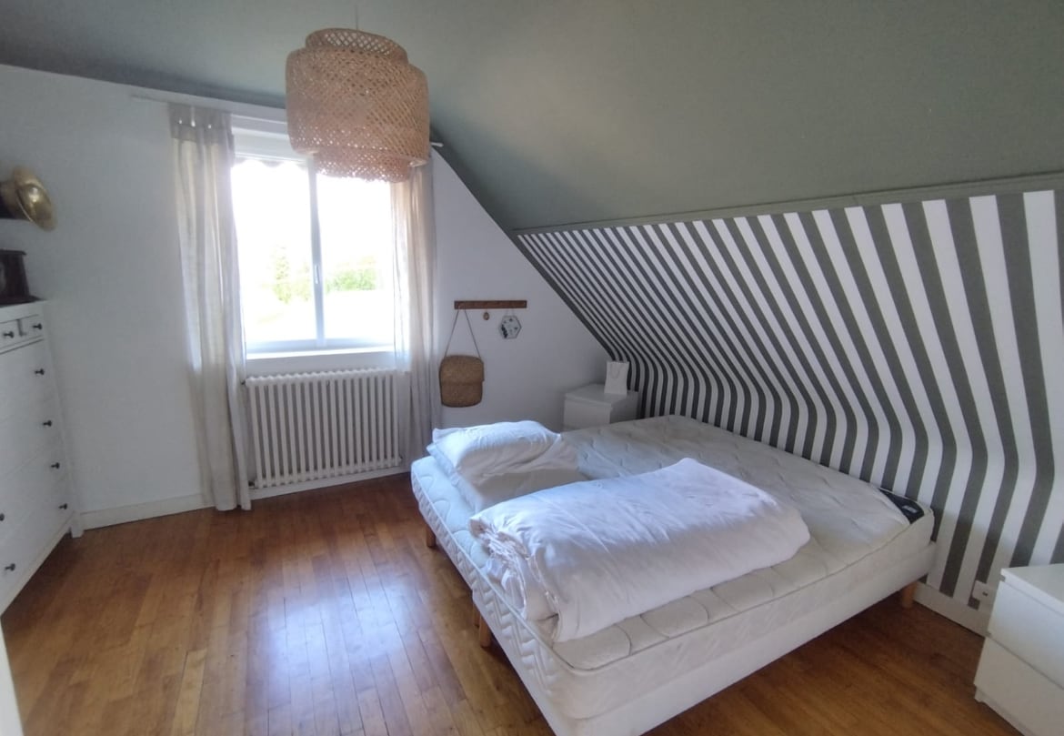 Slaapkamer boven met een persoonsbed en badkamer naast de deur 