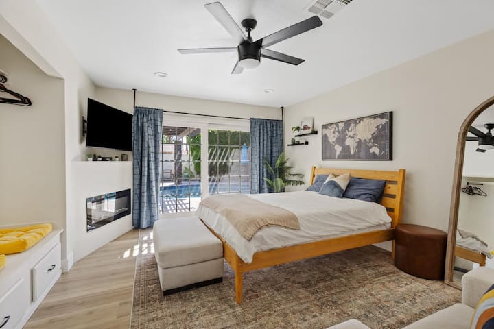 غرفة النوم الرئيسية في الطابق السفلي 3.  تشمل وسائل الراحة في الغرفة باب منزلق إلى الفناء الخلفي ومدفأة كهربائية وديكور أنيق مع حمام داخلي. 