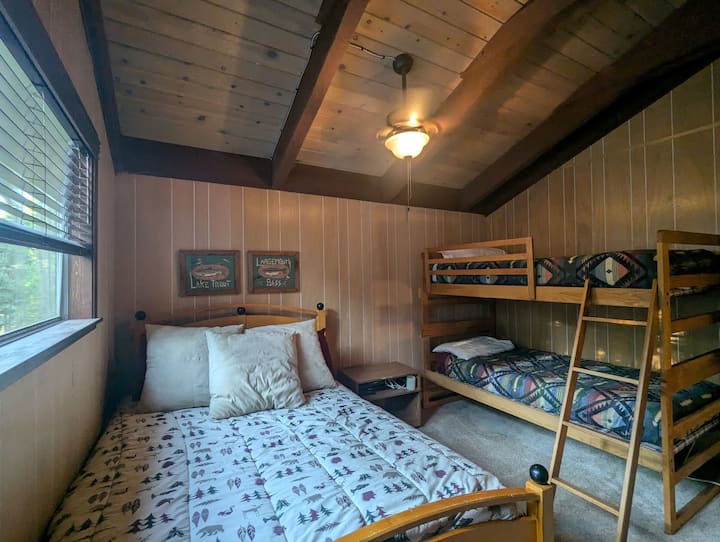 Спална соба на горниот кат со кревет во целост и кревети на спрат. Плакарот и фиоката им се достапни на гостите.