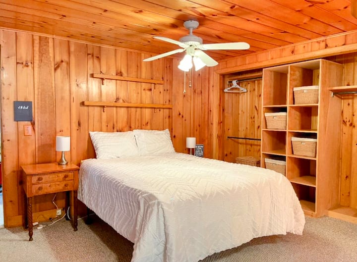Main cottage master bedroom with a queen size bed and air conditioning unit.

This bedroom is out from the living area, with its own bathroom.