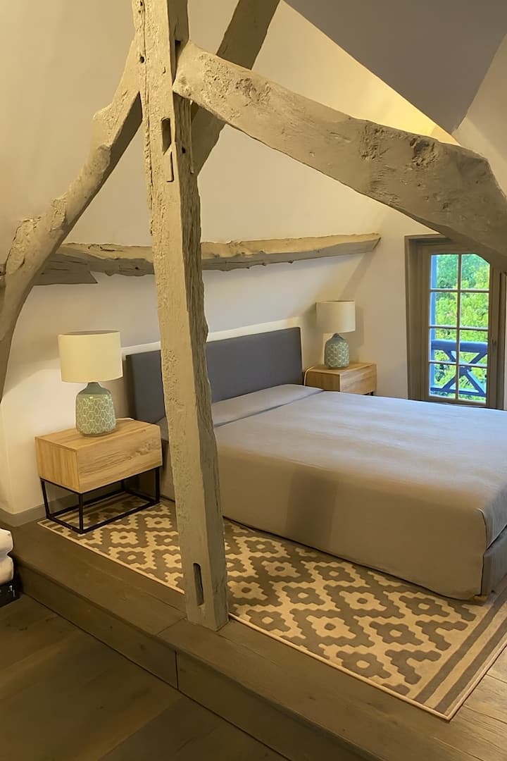 Elegante suite bajo vigas a la vista, que combina el encanto auténtico y el confort moderno, con una zona de relajación y baño en suite
