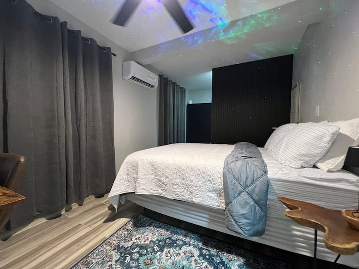 Spavaća soba br. 2, soba Aurora, ima bračni krevet, mini split klima-uređaj, stropni ventilator, prostor za rad, prostor za odlaganje i aurora projektor. 