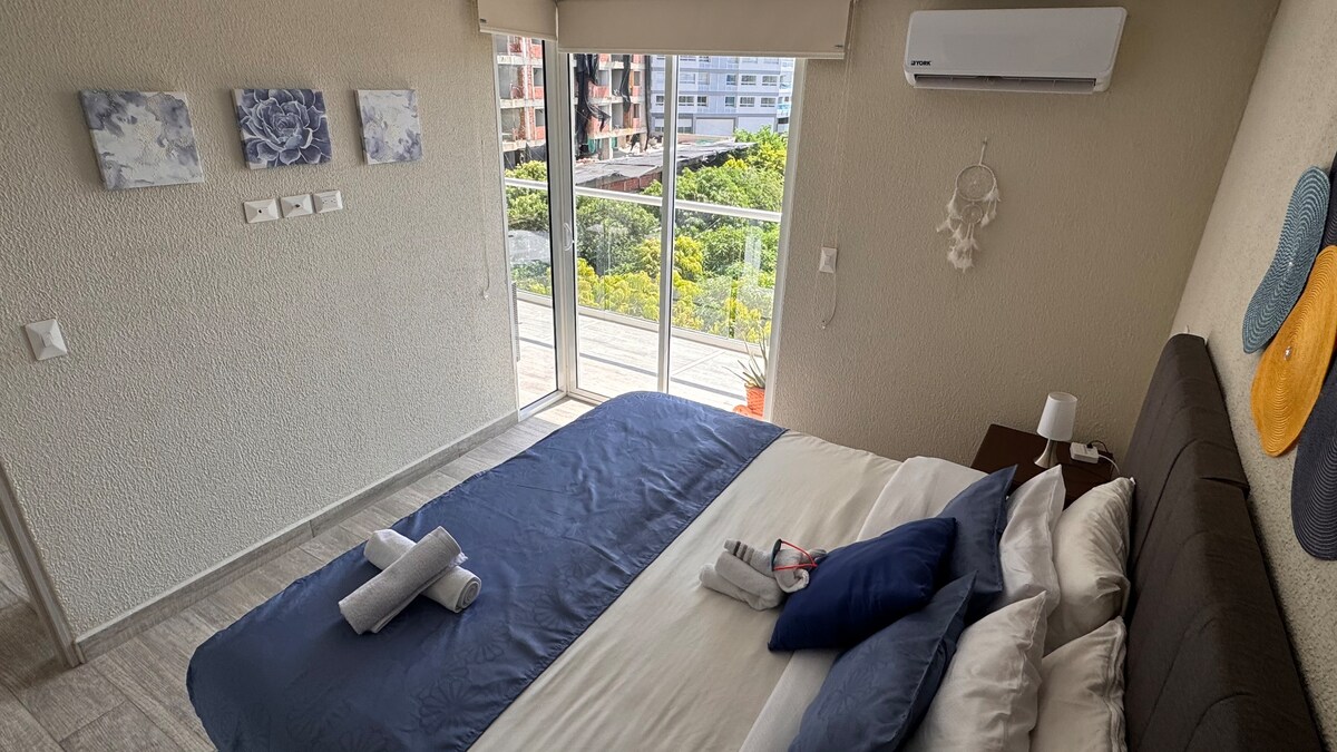 Giường ấm cúng được trang trí đẹp mắt với khăn tắm mới, tầm nhìn ra đường phố và lối đi thẳng ra ban công - thức dậy với sự quyến rũ của Cartagena mỗi buổi sáng