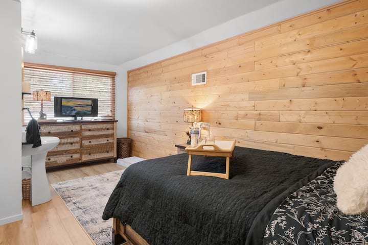 Msingi wetu una kitanda aina ya queen, kitanda cha mtoto kidogo cha stowaway, televisheni iliyounganishwa na fimbo ya moto ya Amazon, saa ya king 'ora yenye uwezo wa kuchaji wa USB, bandari ya kuchaji kwa simu yako, Apple Watch & AirPods pamoja na choo cha chumba