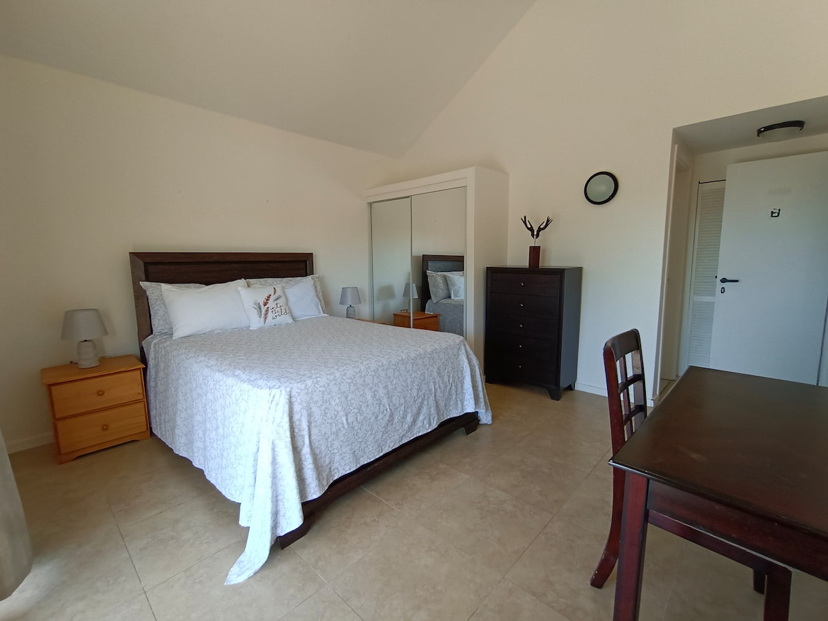 חדר שינה ראשי קריר ומרווח, אידיאלי למנוחה ולישון לצלילי גלי האוקיינוס.