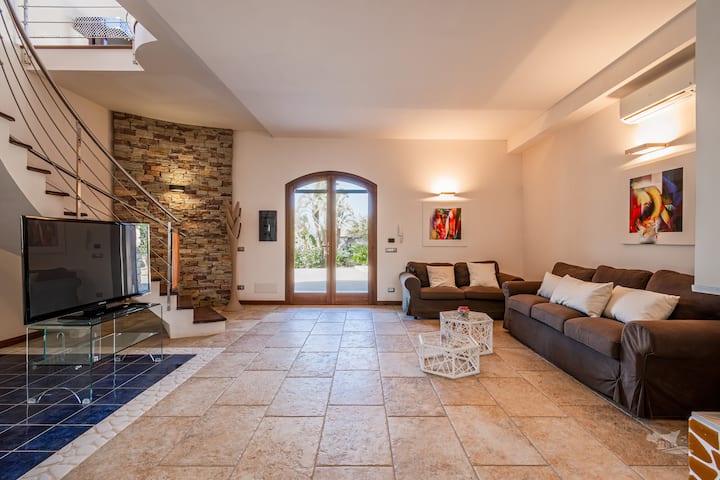 تنضح غرفة المعيشة الواسعة والمصممة بشكل جميل بالأناقة، مع لمساتها الحجرية الطبيعية والإضاءة الناعمة التي تخلق جوًا جذابًا. يوفر ملاذًا هادئًا ومثاليًا للاسترخاء أو مشاركة اللحظات الحميمة.