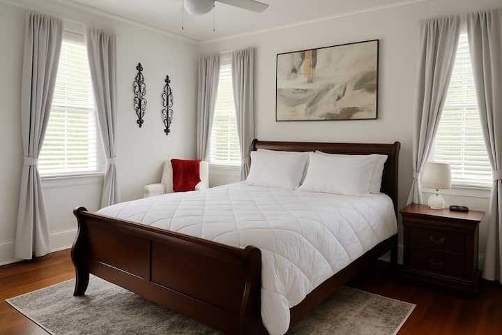 חדר שינה עם מיטת קווין סייז וכיסא ישיבה 