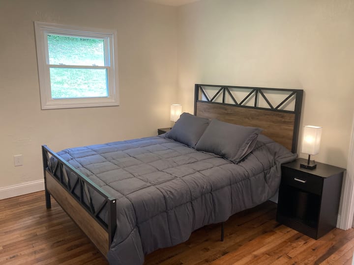 Едно двойно легло с две нощни шкафчета.  Всяко нощно шкафче има светлина с USB портове и контакти.  Тази спалня разполага със самостоятелна баня.